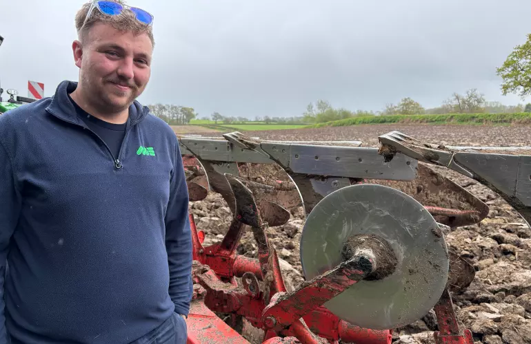 Martin Evans Contractor - Operator standing next to plough in field