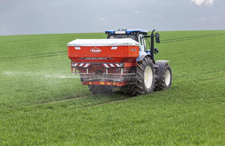 KUHN fertiliser spreader in a green field 