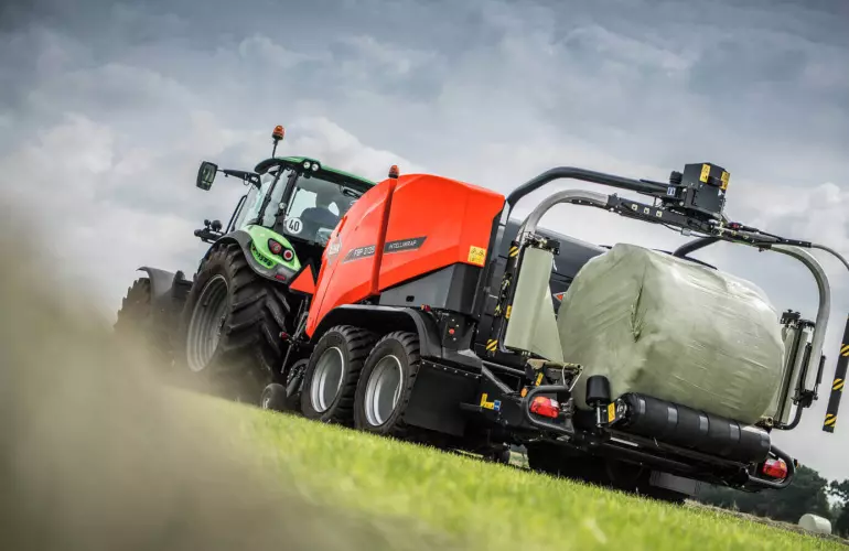 FBP 3135 wrapping a bale under a cloudy sky