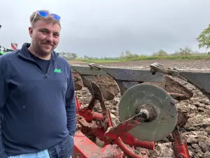 Martin Evans Contractor - Operator standing next to plough in field