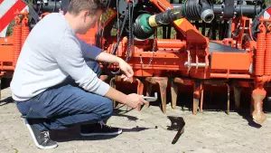 a man replaces power harrow tines