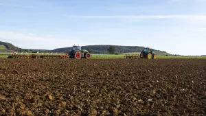 field being ploughed by 2 tractors