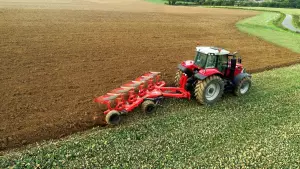 view of a tractor ploughing for incorporation of organic materials