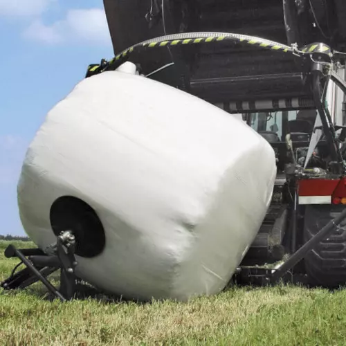 Turning bales at a flat side after wrapping