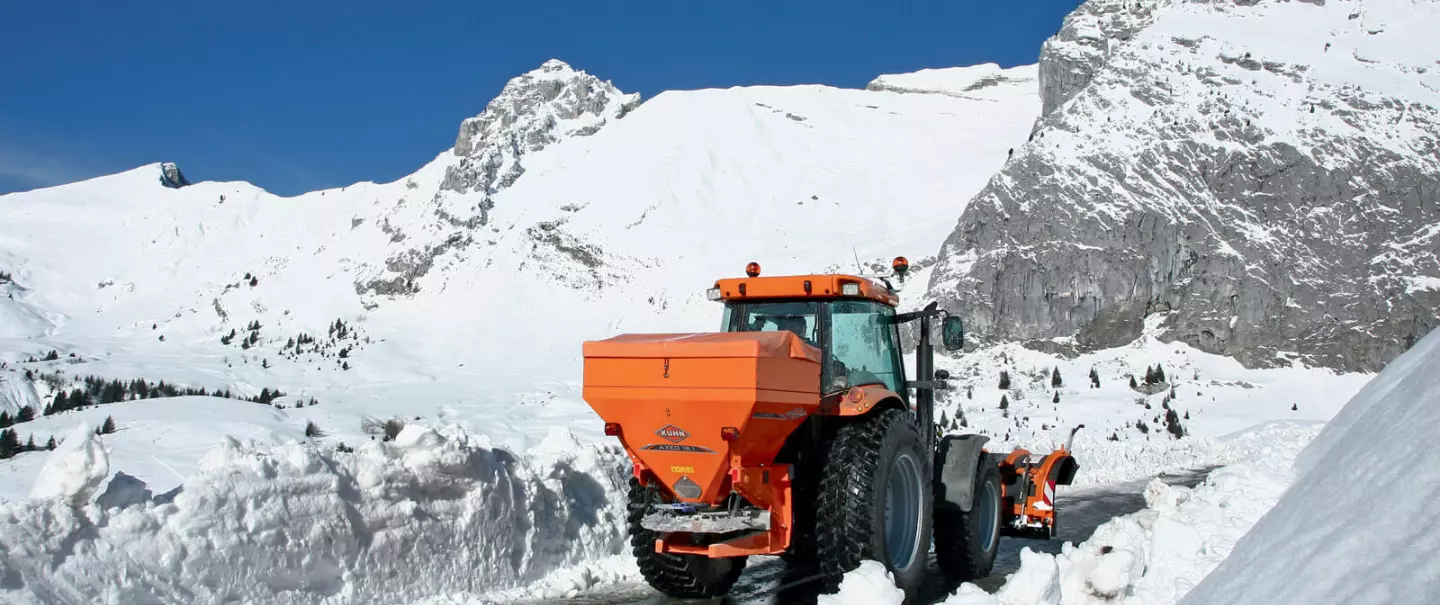 AXEO salt, sand, gravel and fertiliser spreader at work on a mountain road in the snow